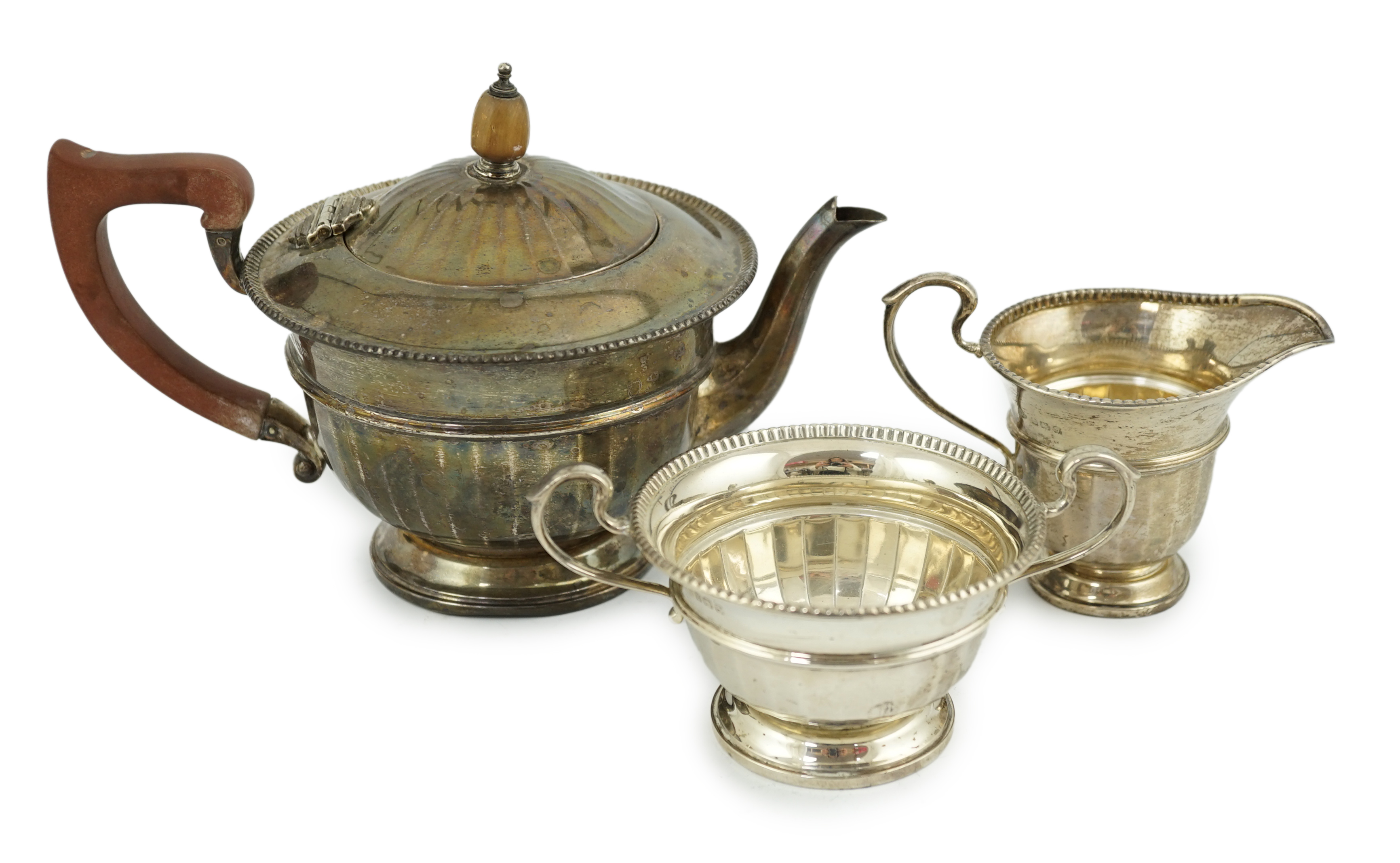 A George V panelled silver three piece tea set, by Adie Brothers